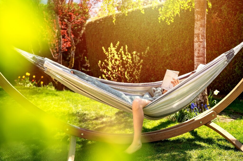 Person entspannt in einer Hängematte im Garten