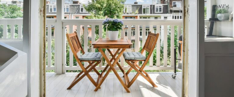 Holzstühle und Teetisch auf dem Balkon